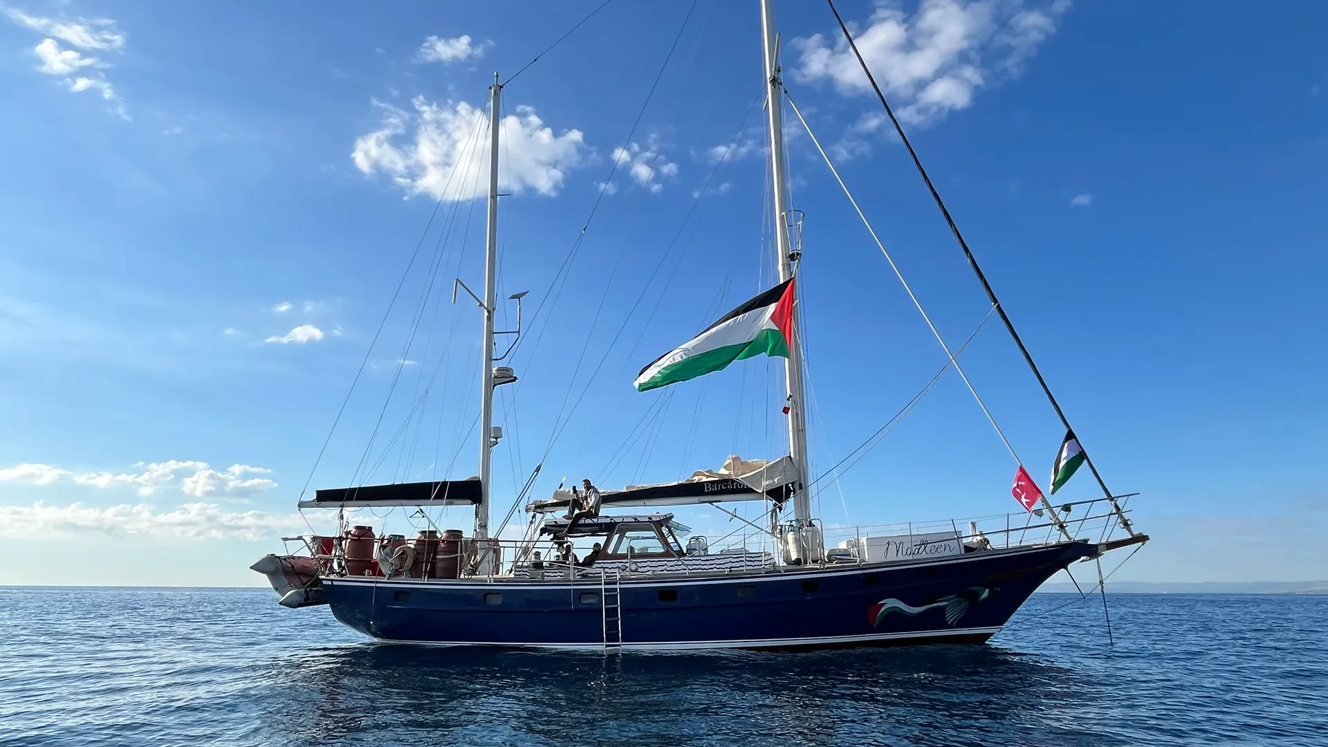 A sailboat flying the Palestinian flag at sea.